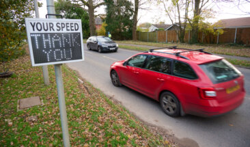 Car driving past speed sign