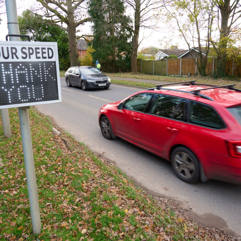 Car driving past speed sign