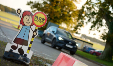 Car driving past slow down sign