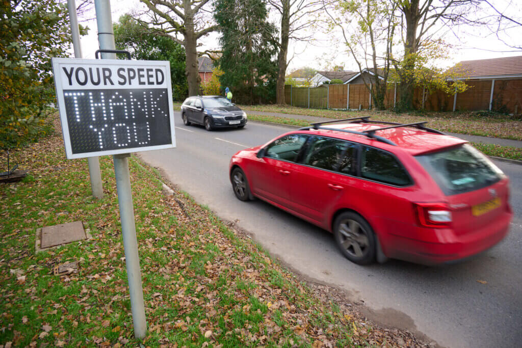 Car driving past speed sign