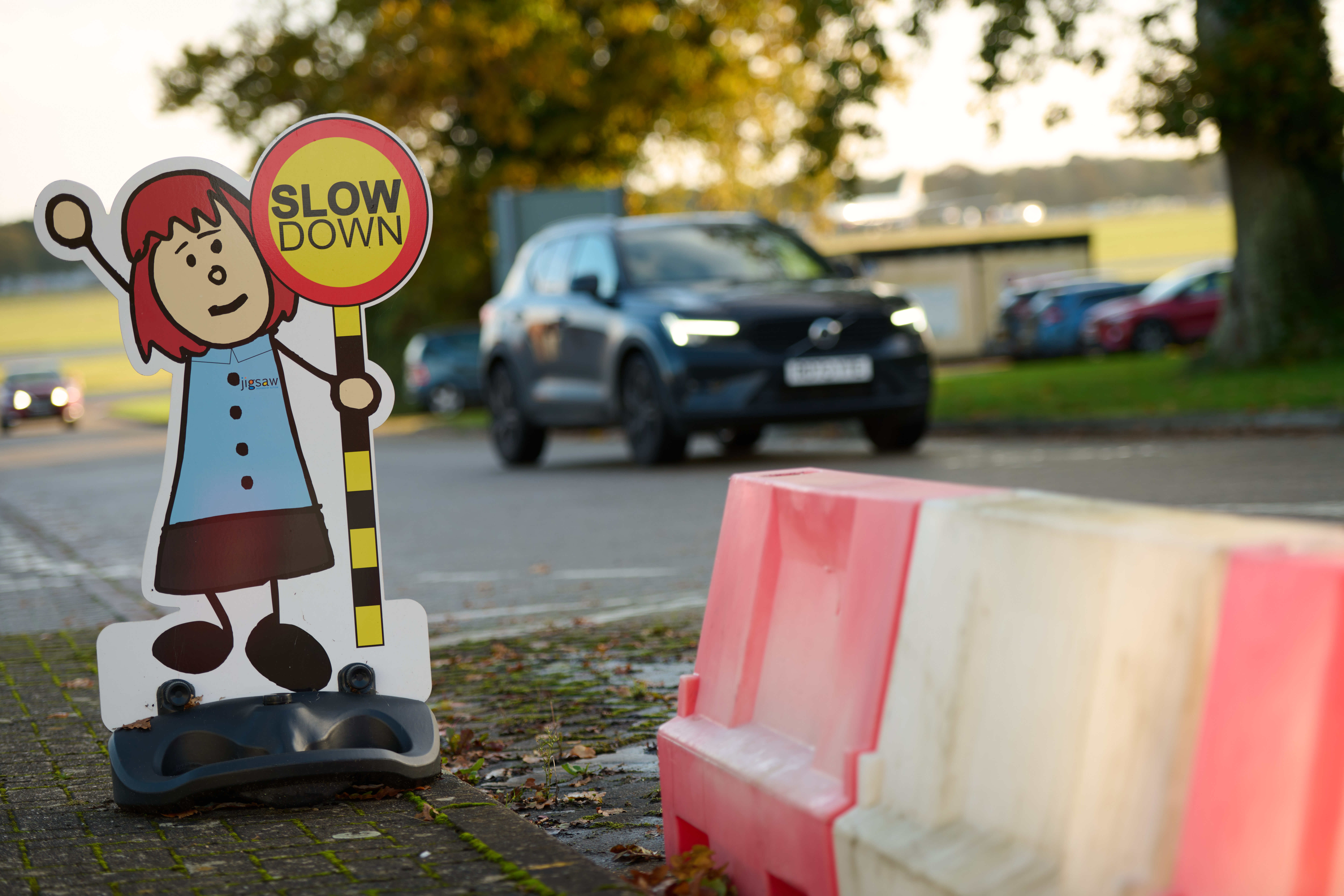 Car driving past slow down sign