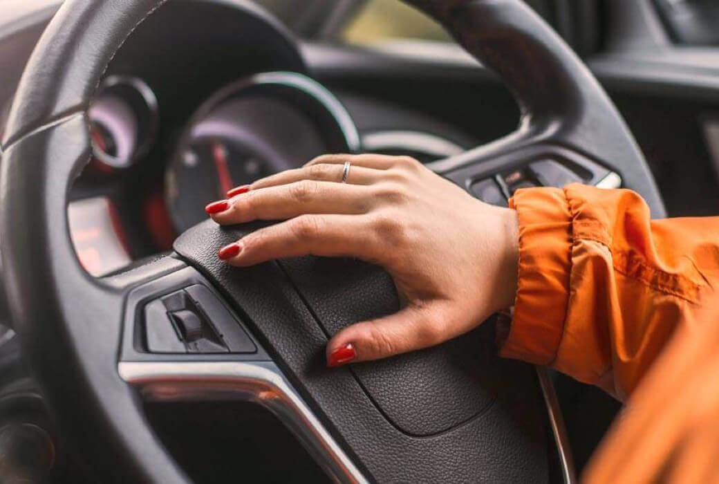 Female hand on steering wheel