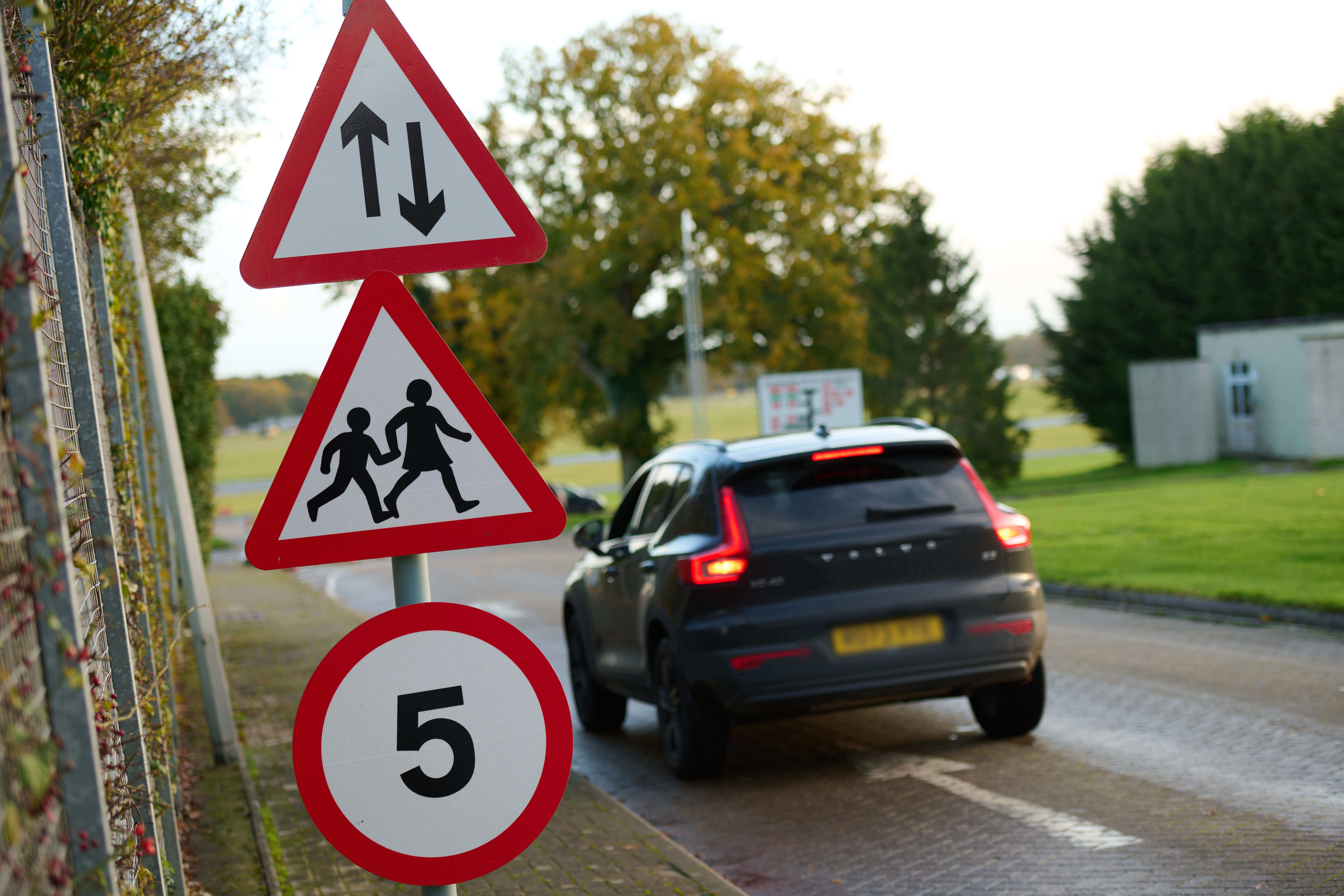 Car on road with school signs